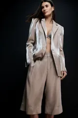 Blazer de mujer con acabado metalizado en tono champagne, solapas clásicas y hombros definidos con estructura, diseño de líneas depuradas.