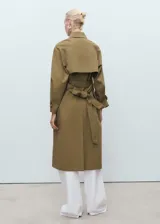 Abrigo tipo trench de diseño recto y oversize, color verde oliva. Presenta cierre de doble botonadura, cuello de solapa ancha, bolsillos laterales y mangas largas con puños abotonados. Incluye forro interior y cinturón desmontable.