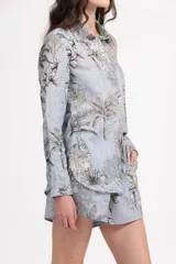 Short celeste con estampado de palmeras, leopardos y hojas. Tiene cintura elástica y bolsillos laterales.