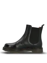Botin estilo chelsea de cuero negro con paneles elásticos laterales, suela de goma dentada con costuras amarillas contrastantes y tirador trasero.