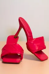 Sandalias fucsia con taco fino y tira ancha trenzada.
