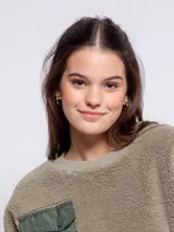 Sweater negro peludito de manga larga y cuello a la base con puños en las mangas y un bolsillo de nylon frontal con solapa y botón.