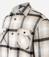 Campera trucker masculina de terciopelo a cuadros en tonos beige, blanco y negro, con cuello inglés, cierre abotonado, bolsillos cargo y forro interno de sherpa.