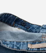 Pantalón mom jeans con lavado marmol, tiro alto, bolsillos y ajuste interno en la cintura.