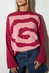 Sweater de punto con diseño de espiral en contraste, cuello redondo y mangas largas con corte holgado.
