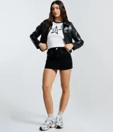 Remera de algodón color blanco con cuello y bordes de mangas en color negro. Presenta una estampa frontal central con el número 98 dentro de una estrella con efecto desgastado.