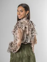 Camisa de seda italiana con diseño reversible, permitiendo usar el lazo en la parte frontal o posterior. Presenta un estampado sutil con motivos abstractos y animal print, cuello alto con volados, mangas largas con puños elásticos y corte holgado.