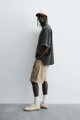 Bermuda de denim de algodón, color verde claro lavado, de corte recto y tiro medio. Presenta cinco bolsillos y cierre frontal con cremallera y botón.