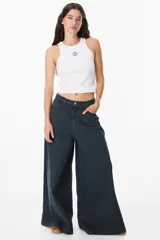 Jean de corte wide leg en color negro lavado, con tiro medio y cierre de botón y cremallera. Presenta bolsillos traseros amplios y etiqueta de cuero sintético con el logo de la marca en la parte posterior.