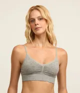 Soutien top alargado color gris melange, confeccionado en microfibra sin costuras. Presenta diseño con escote en V con detalle de encaje, frunce central en el busto, banda inferior elastizada tipo rib y tirantes finos regulables. Incluye copas desmontables.