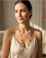 Collar de cadena fina con baño de oro, adornado con piedras naturales de diversos colores y formas ovaladas distribuidas a lo largo de la pieza.