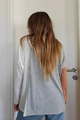 Polerón de cuello alto con diseño tricolor en bloques, confeccionado en tejido de punto acanalado. Presenta una manga en color tostado, el cuerpo central en gris y la otra manga junto con el lateral en color blanco.