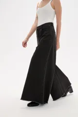 Pantalon de jean azul de corte ancho y tiro alto, con ruedo deshilachado.