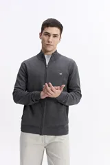 Campera tejida de algodón en color beige, con cierre frontal completo, cuello levemente elevado y puños y ruedo acanalados. Presenta un pequeño logo bordado en el pecho.