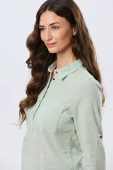 Camisa de lino lisa color celeste, de manga larga con puños abotonados y trabilla para arremangar. Cuenta con cuello clásico, cierre frontal con botones y bolsillos plaqué en el pecho.