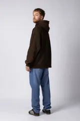 Buzo canguro de frisa gruesa con capucha, diseño oversize y acabado con efecto gastado. Presenta recortes horizontales en el frente y puños con elástico.