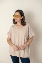 Remera color beige de corte holgado, escote en V y manga corta.