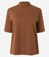 Remera negra de algodón, corte amplio, cuello alto en punto roma y mangas cortas.