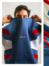 Buzo de algodón de corte premium con diseño de bloques de color en las mangas, cuello redondo y logo bordado en el pecho. Presenta costuras reforzadas y mangas anchas.