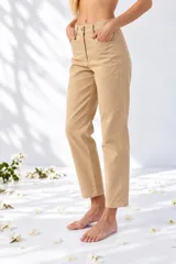 Pantalón de gabardina color beige, de corte recto y holgado, tiro medio con bolsillos delanteros y traseros.