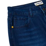 Pantalón de jean azul índigo con diseño de cinco bolsillos, cierre de cremallera y botón metálico. Presenta un corte ajustado a lo largo de la pierna y un acabado de lavado localizado en la parte frontal.