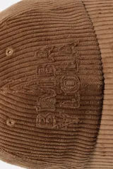 Gorra de diseño clásico confeccionada en tejido de pana, con visera curva y logo bordado en el frente.