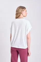 Camiseta blanca de algodón con corte holgado y mangas cortas tipo sisa.