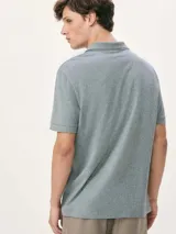 Polo de hombre color gris oscuro jaspeado, con cuello y puños de manga con ribete negro. Presenta un pequeño logo bordado en el pecho.