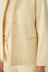 Chaqueta corta con cuello solapa, manga larga con coderas aplicadas, cierre frontal con botones y bolsillos ojal. Con forro.