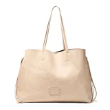 Cartera tipo tote de gran tamaño en color taupe, confeccionada en símil cuero con textura granulada. Presenta doble asa larga para llevar al hombro, cierre de cordones laterales y placa metálica frontal con logo grabado.
