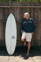 Buzo gris oscuro de tejido waffle con cuello polo y cierre frontal de botones. Presenta el texto "glassy waves" estampado en el pecho en tono claro.