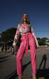 Pantalón fucsia de cuero sintético, corte recto, tiro alto y lazo en la cintura.