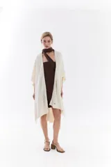 Ruana de punto color beige con detalles texturizados y tramados abiertos, ligera y versátil.