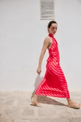 Falda midi fluida confeccionada en tejido satinado con estampado de rayas diagonales en tonos rojo y rosado, y cintura elástica.