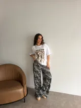 Remera oversize de algodón negro, con diseño gráfico frontal que incluye la leyenda "COFFEE CLUB" y una ilustración estilo retro de una mujer bebiendo café.