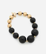 Collar maxi de esferas grandes de resina negra combinadas con pequeñas cuentas doradas.