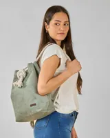 Mochila tipo bolso de tela color verde musgo con cordones de soga gruesa.