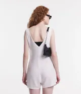 Enterito corto color blanco hueso, con escote en V, breteles anchos y bolsillos laterales.