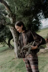 Campera tipo bomber color chocolate, con cierre frontal, cuello redondo tejido y mangas abullonadas.