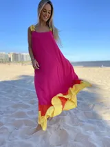 Vestido largo de tirantes color fucsia con volados en el ruedo en amarillo y naranja.