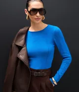 Suéter de punto color azul vibrante, con corte ajustado, cuello redondo y mangas largas. Presenta detalles de nervaduras verticales a lo largo de la prenda que estilizan la silueta.