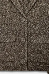 Chaqueta de punto con textura jaspeada, cuello solapa y manga larga. Presenta bolsillos delanteros de plastrón con solapa y cierre frontal con botones forrados a tono.