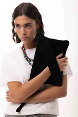 Cartera tipo sobre de cuero gamuza color negro, con diseño versátil que permite cuatro formas de uso: como sobre, colgado a la muñeca, al hombro o como bandolera. Incluye correa larga extraíble y correa corta para la muñeca.