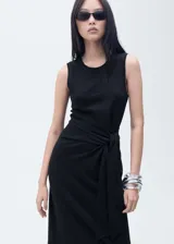Vestido midi de algodón color negro, con cuello redondo, sin mangas y detalle de nudo lateral en la cintura que crea un drapeado sutil.