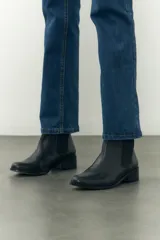 Botinetas negras de cuero con elástico lateral y taco bajo.