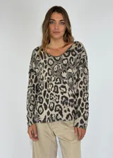 Blusa beige con estampado animal print de leopardo en tonos marrones y negros, de mangas largas y escote redondo amplio.