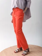 Pantalón de jean recto color naranja con costuras blancas.