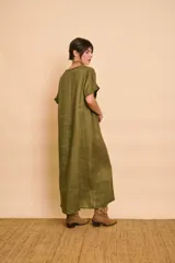 Vestido tipo túnica largo de lino color beige, de manga corta, con detalles de volados en el frente y bolsillos laterales.