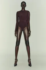 Body de manga larga color marrón oscuro, con escote asimétrico drapeado y detalle de broche metálico en el hombro derecho.