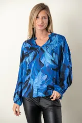Blusa estampada en tonos de azul, de seda y viscosa, con escote en V y mangas largas terminadas en puño elástico.